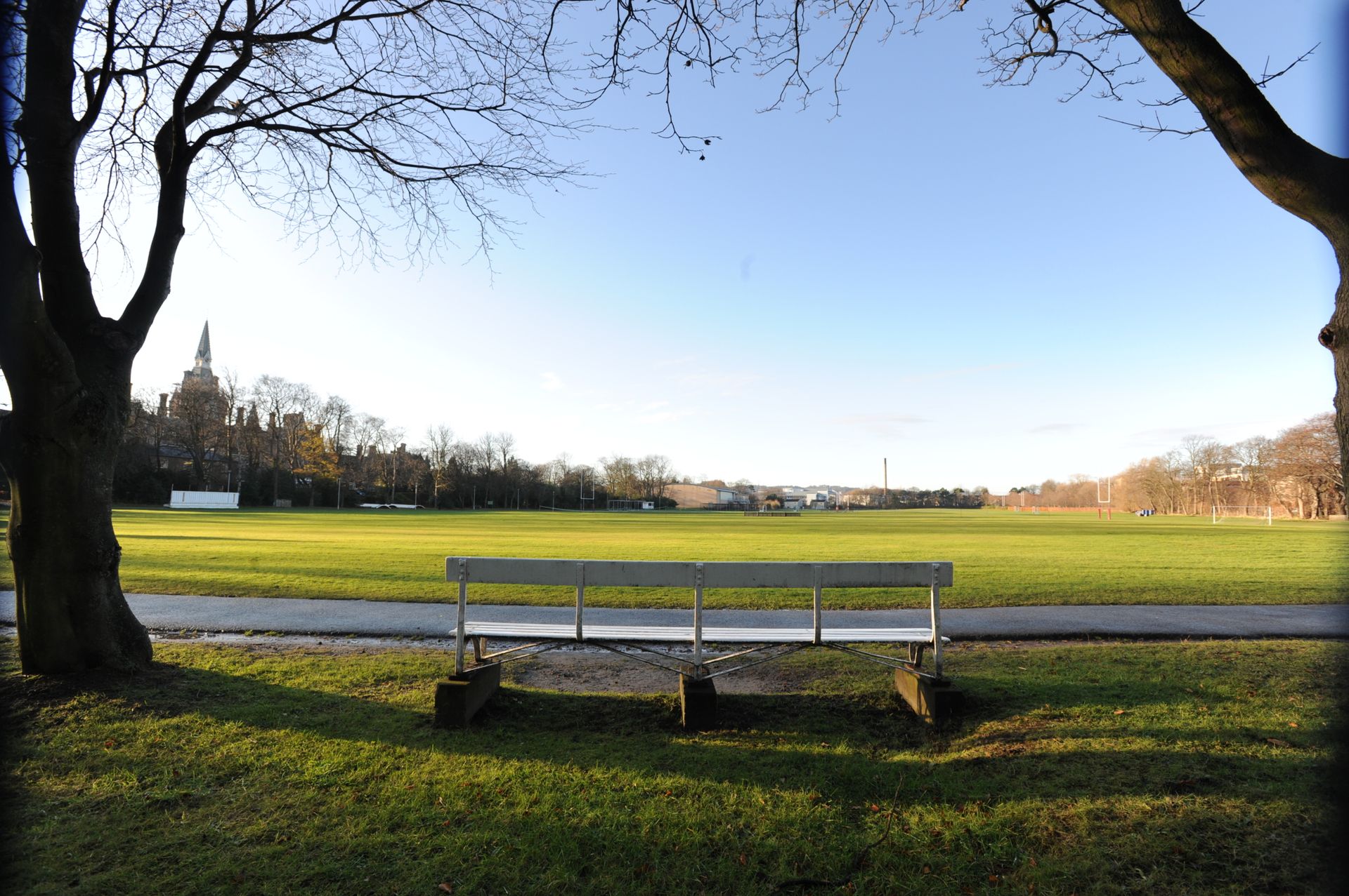 Shows a bench in the forefront and Bigside pitches in the background