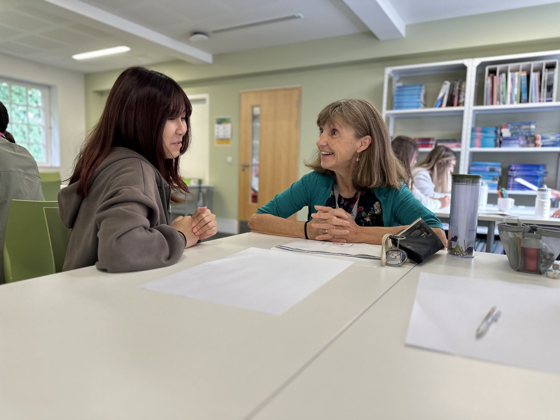 Image of teacher and student smiling whilst working on something